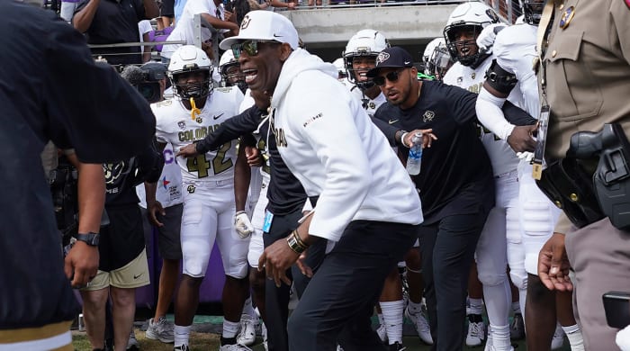Colorado coach Deion Sanders runs onto the field with his team for a an NCAA college football game against TCU.